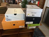 Stack of original shoe boxes for Aldo, Nine West, Naturalizer, Unisa showing sizes and brands