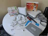 Overall view of console, Balance Board, controllers, games, cables and manual on table