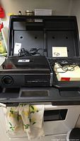 Complete view of Kodak Carousel Custom 860H slide projector with power cord, instruction manual, and open carrying case.