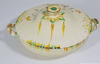 Top angle showing the lid with knob, handles and floral and linear color designs.