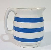 Side view showing handle and blue bands on ceramic pitcher