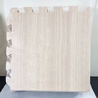 Single foam floor mat tile with interlocking edges and wood grain pattern in light walnut color.
