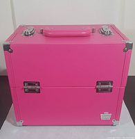 Front view of the bright pink Caboodles train case with metal corner protectors and chrome latches visible.