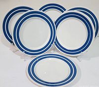 Front view of all six side plates arranged upright on stands, showing the blue and white striped pattern.