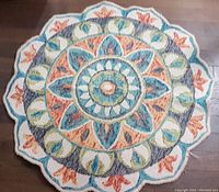 Top-down photo of star-shaped multicolor rug showing full design and scalloped edges.