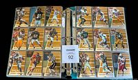Binder pages open displaying multiple gold-bordered football cards including notable players from the 1996 season.
