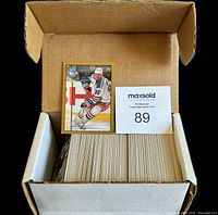 Box with 242 hockey cards and one card displayed on top featuring a player in a blue and white New York Rangers jersey.
