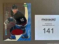 Front side of the Daniel Sedin Parkhurst 2001-02 game used jersey insert card featuring the player image and a red fabric piece from his jersey.