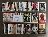 Photo of multiple hockey cards arranged in rows showing a range of players including Gretzky, Lemieux, Yzerman, Roy, and Orr with a MaxSold tag showing number 9.
