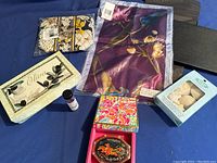 Lot overview showing the silk scarf packaging, makeup bag, soap boxes, button loops, and decorative boxes