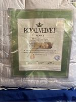 Royal Velvet Venice label showing product details including 275 thread count cotton cover, 70% feather and 30% down fill, sizing and warranty info.