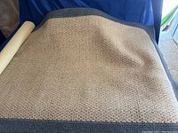 Full view of the beige and gray bordered 3x5 rug spread out showing texture and color.