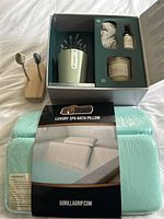Overview photo showing boxed items and spa bath pillow in packaging with label.
