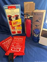 Fire extinguishers, fire blankets, battery-operated light shown outside the box and in original packaging.