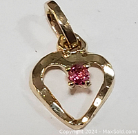 Front view of the 10K yellow gold heart-shaped pendant with pink sapphire gemstone in center, showing shape and gemstone color.