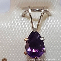 Close-up photo showing the front of the teardrop-shaped amethyst pendant with six claw fasteners and yellow gold setting.