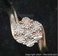 Close-up frontal image of the sterling silver ring showing the 7 diamond chips set in a flower-like cluster on top.