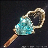 Close-up photo of the blue topaz heart-shaped gemstone set in sterling silver ring, showing facet details and prong setting.