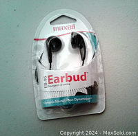 Front view of new Maxell EB-95 earbuds in original sealed packaging, showing brand, model, and earbuds visible inside clear plastic.