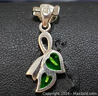Close-up photo of the sterling silver green leaf pendant showing the green leaf-shaped inlays and pendant loop.