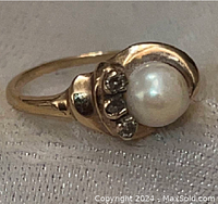 Top view showing pearl center and three diamond accents in swirl setting