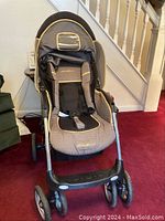 Front view of the Eddie Bauer edition baby stroller showing padded seating, canopy with peek-a-boo window, and double front and rear wheels.