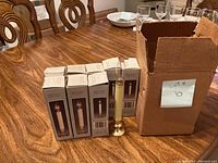 10 battery powered candles displayed on wooden table with one candle out of box and the rest in original packaging alongside a cardboard box