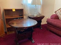 Two wood end tables placed in a family room setting. One table shown opened with round top, other closed as rectangular.