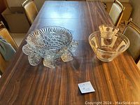 Photo showing the clear glass dip and chip bowl with pedestal base and the punch bowl with matching cups on the dining table.