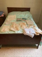 Curtains laid out on bed, showing different panels and sizes, mostly light-colored fabric with some lace