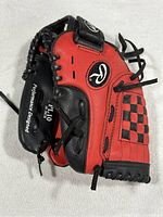 Front view of red Rawlings PL10 baseball glove showing black laces, Rawlings logos, and checkered detail.