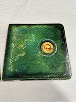 Green snakeskin pattern gatefold sleeve with gold coin emblem on cover