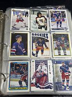 Photo of hockey cards in binder page showing players from New York Rangers and Colorado Rockies