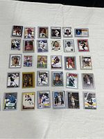 Image showing all 30 hockey cards arranged in 5 rows of 6 on a white cloth background. Cards are in plastic sleeves showing various players and designs.