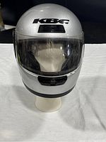 Front view of gray KBC TK-7 motorcycle helmet on a white mannequin head showing clear face shield.