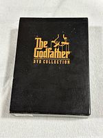 Black rectangular box with gold text 'The Godfather DVD Collection'