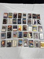 Top view of 40 vintage cassette tapes arranged in rows on a white sheet, showing album cover art and titles.