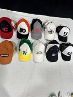 Top view of 10 vintage-style baseball caps arranged in two rows showing logos and colors clearly