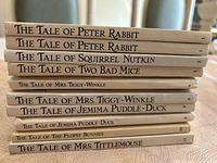 Stack of 10 Beatrix Potter children's fiction books showing spines with titles and numbering