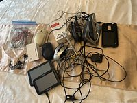Panasonic cordless phone base and handset, Motorola Talkabout radio, two Magellan GPS units, TP-LINK WiFi extender, three computer mice, cell phone case, miscellaneous cables.
