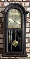 Full view of Citizen wall clock with wooden case, glass front, Roman numeral clock face, weights, and pendulum.