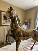 Side front view of brass horse sculpture on table