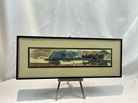 Full view of framed watercolor painting on easel