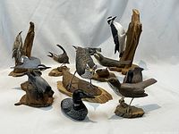 Overview of all eleven bird carvings on white backdrop