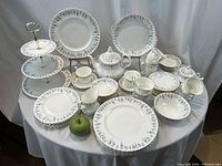 Full display of all 50 pieces on round table with green apple size reference