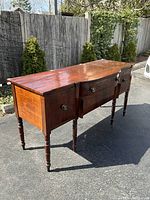 Full view of sideboard showing serpentine front and turned legs