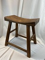 Angled front view of oak zen stool on white backdrop