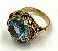 Close-up oblique view of ring showing blue citrine gemstone and yellow gold setting