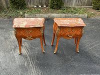 Full front view of both bombe side tables on asphalt