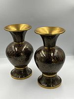 Pair of large, dark base cloisonne vases with gold floral line decorations, brass interior rims and footings, set against a plain background.
